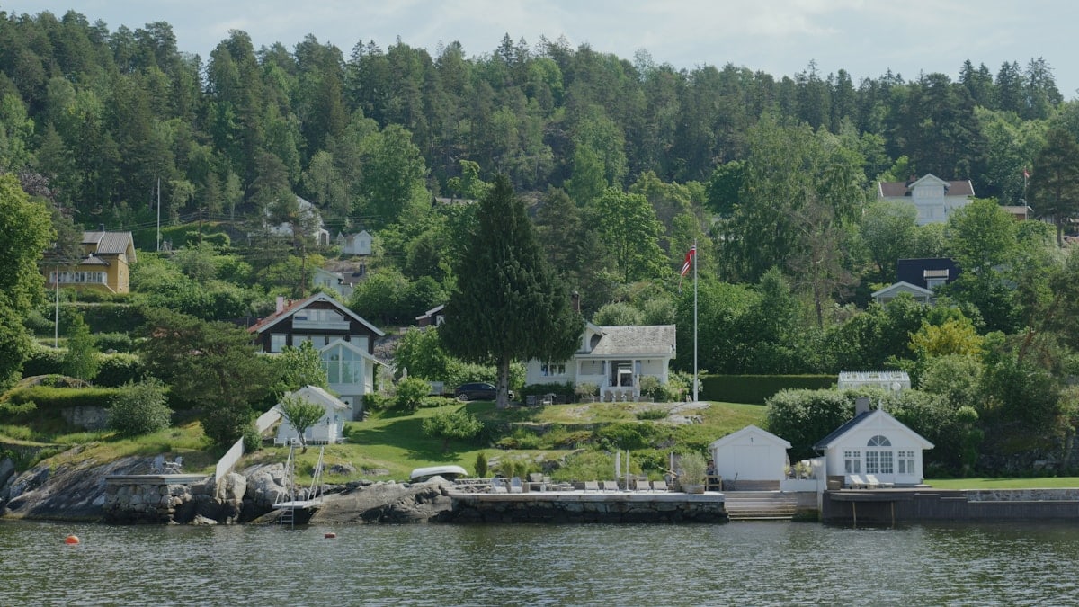 a body of water with houses and trees in the background